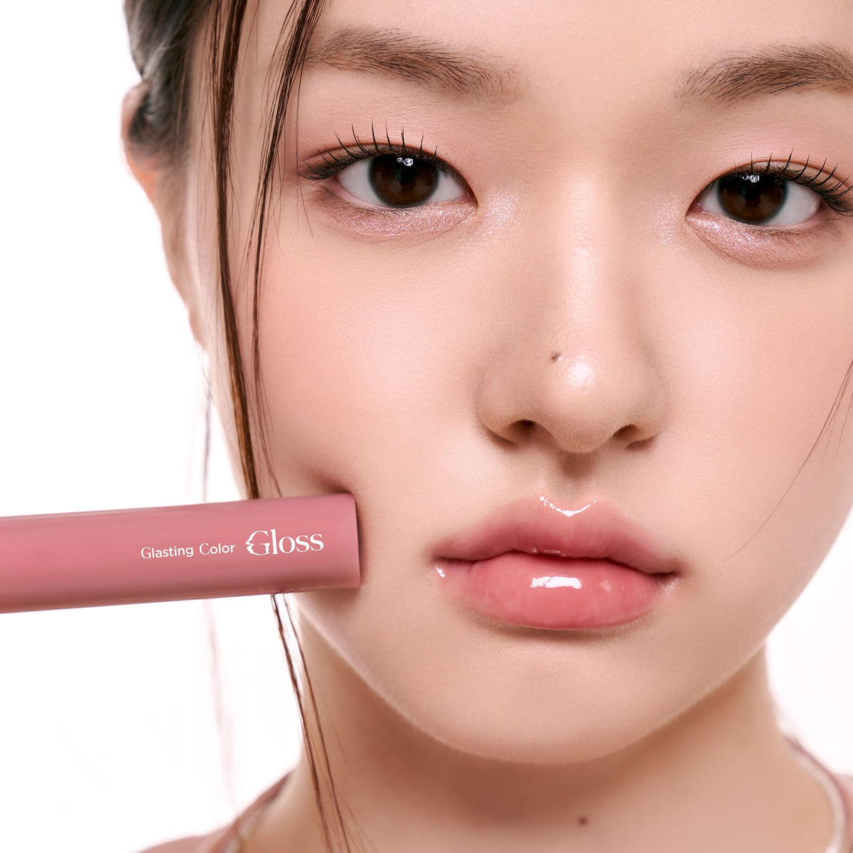 rom&nd swatch on forearm revealing sheer rosy-peony color and glossy effect benefit