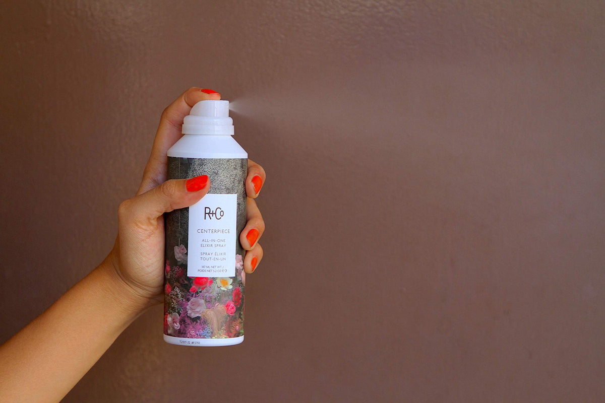R+Co Centerpiece bottle in hand for size comparison, communicates travel-friendly convenience