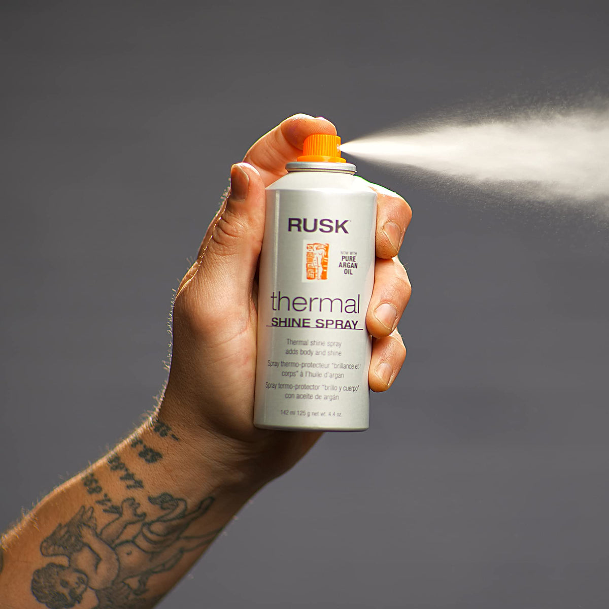 RUSK shine spray in use during blow-drying for frizz control and smooth finish