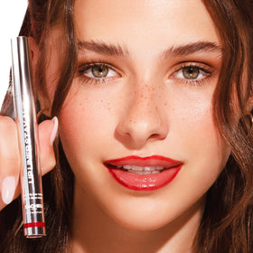 Sacheu next to standard lipstick showing compact travel-friendly size