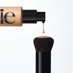 Saie brush next to foundation pump showing scale and product compatibility