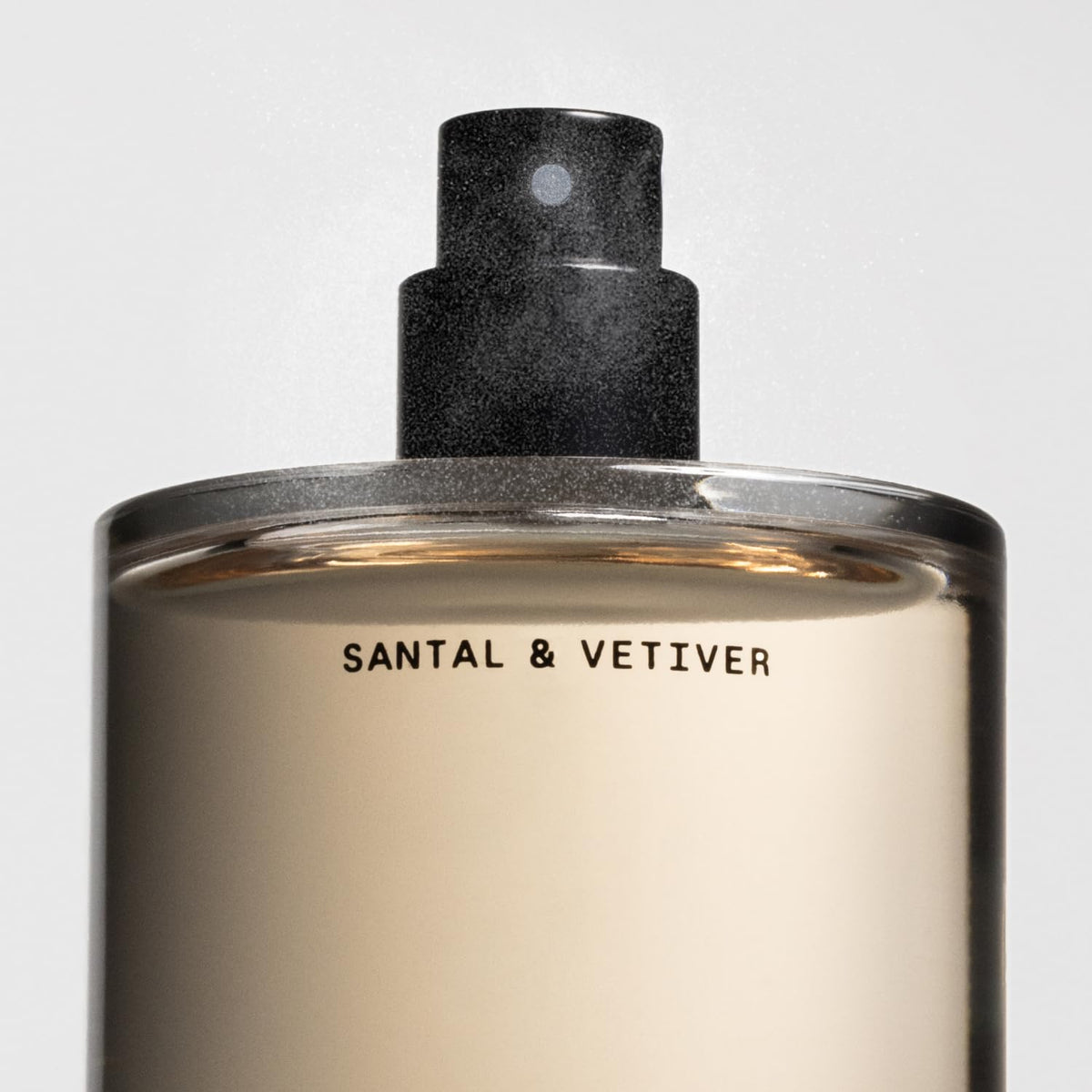 Salt & Stone bottle staged on wood surface in warm lighting, evokes woody scent