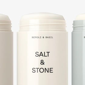 Salt & Stone deodorant next to a hand showing size and portable convenience
