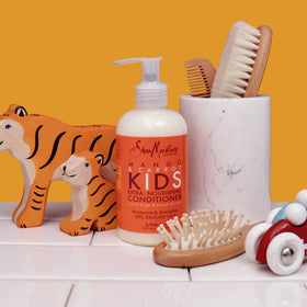 SheaMoisture being applied to a child’s hair easing comb-through