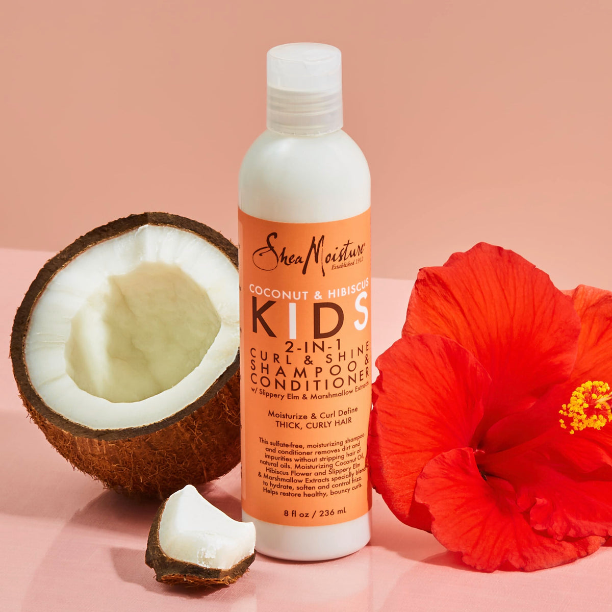 SheaMoisture 8 oz bottle beside common objects showing compact travel-friendly size and convenience