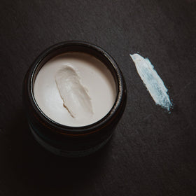 Shear Revival jar on bathroom counter with grooming tools, suggests daily routine integration and scent