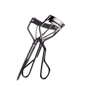 Shiseido eyelash curler front view showing broad curve and safe design benefit