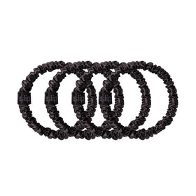 Slip packaging set of four black silk scrunchies indicating gift-ready convenience