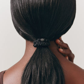 SLIP scrunchie styled in a low bun on model showing polished look and hair protection