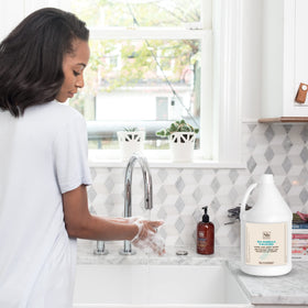 Hand next to Soapbox gallon for scale showing large-volume convenience