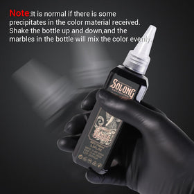 Solong Tattoo 100ml bottle next to credit card illustrating compact studio size