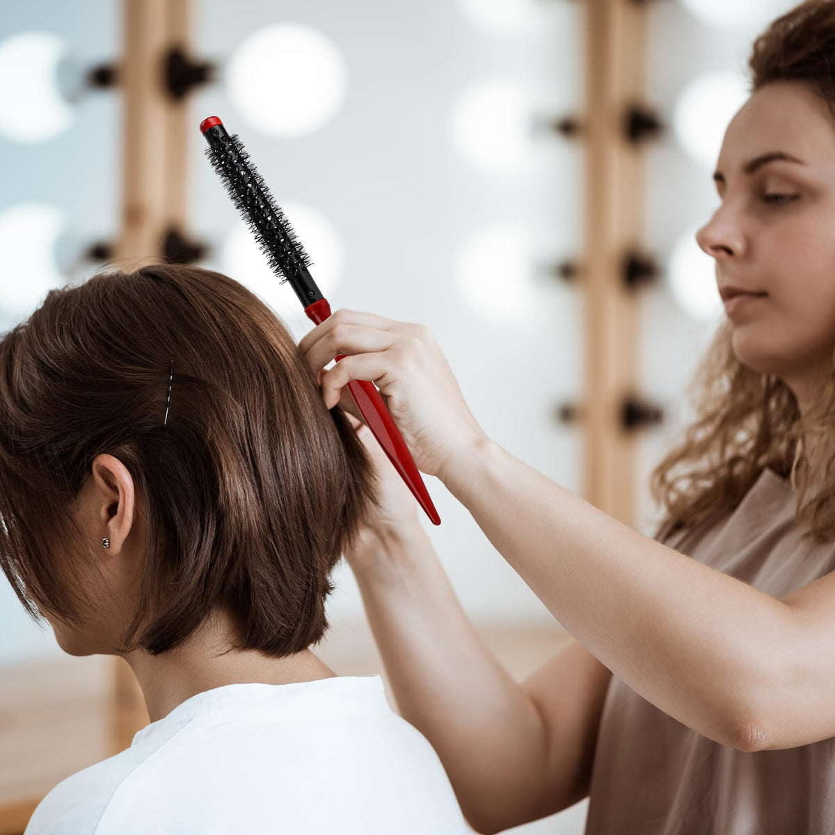 Styquenzer brush in use with hair dryer creating volume on short hair for quick results