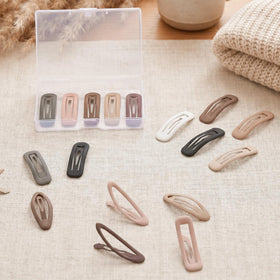 SUMAJU clips in hand for scale showing compact size and travel convenience