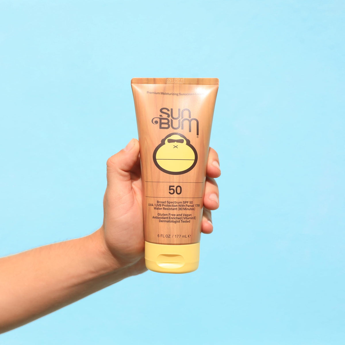 Sun Bum applied on forearm at beach demonstrating non-greasy hydration and water resistance