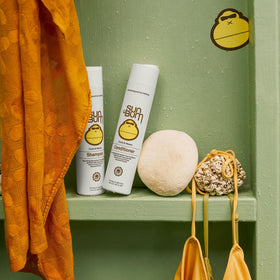 Sun Bum conditioner applied to curly hair in hand for easy detangling