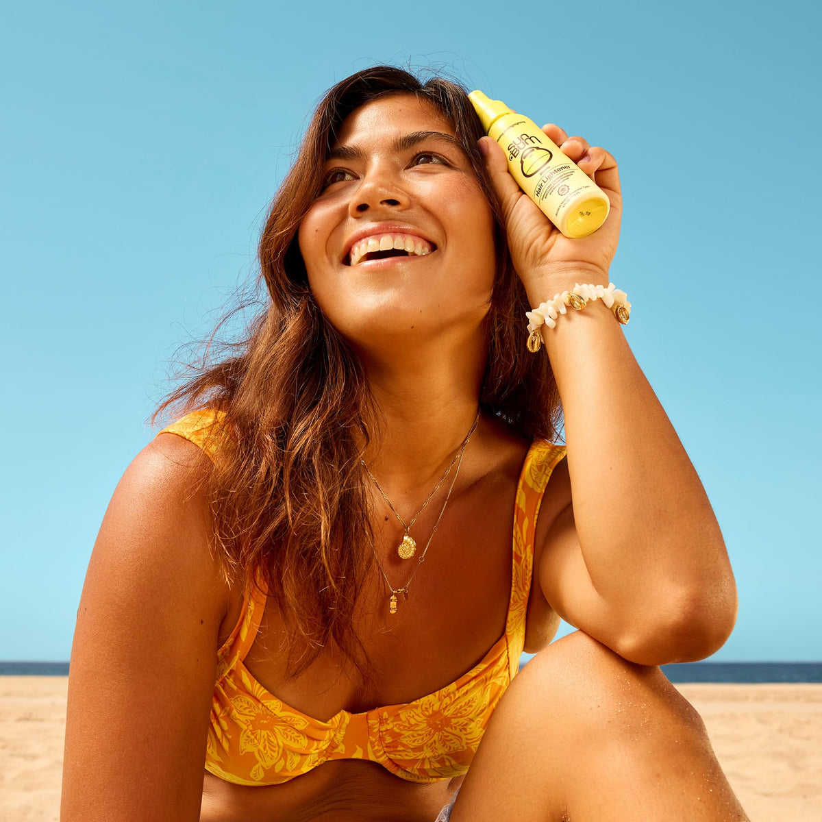 Sun Bum Blonde Formula spray close-up, shows nozzle and UV-activated texture benefits