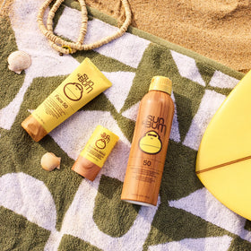 Sun Bum stick next to passport and sunglasses illustrating travel-ready size