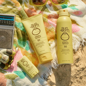 Sun Bum spray in use on child at beach showing quick wet-or-dry protection