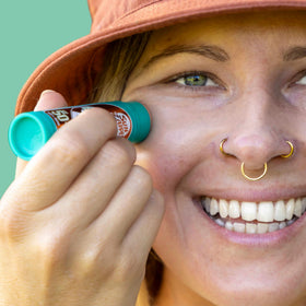 Sun Zapper stick held in hand showing compact 15g size benefit