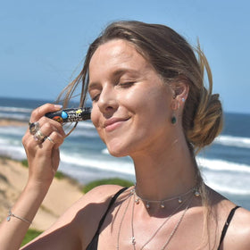 Sun Zapper stick next to a coin showing compact travel-size convenience