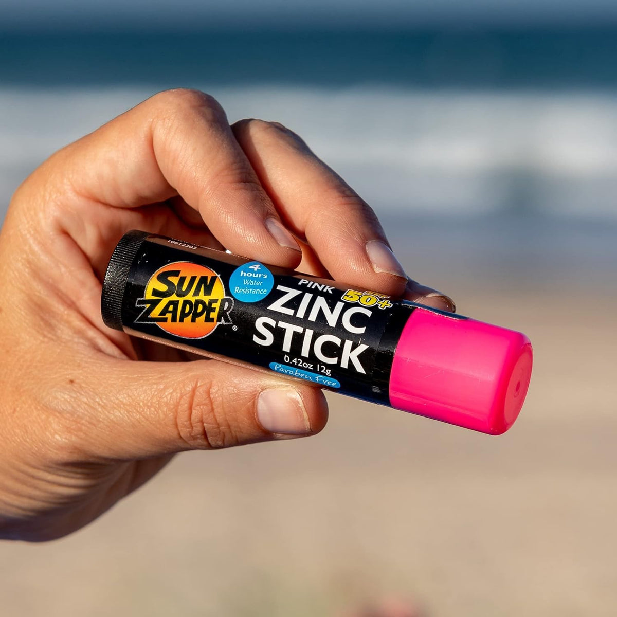 Sun Zapper stick held in hand to show compact travel-friendly 12g size