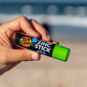 Sun Zapper stick open next to coin size showing travel-friendly scale