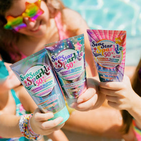 Sunshine & Glitter bottle poolside with towel showing festival and pool-ready protection