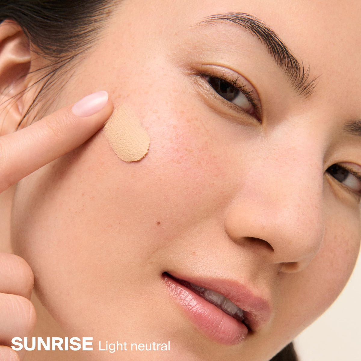 Applying Supergoop! with fingers to show easy spread and mattifying benefit