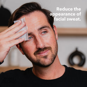 Person applying SweatBlock to forehead demonstrating sweat control benefit