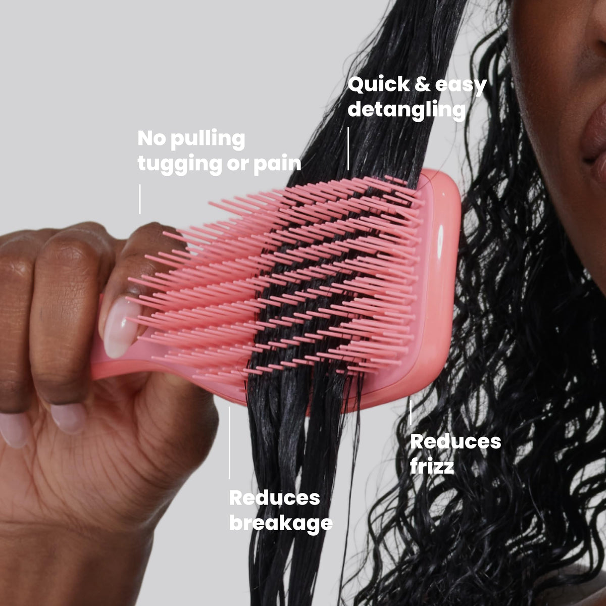 TANGLE TEEZER held in hand to show size and portability for on-the-go curl care