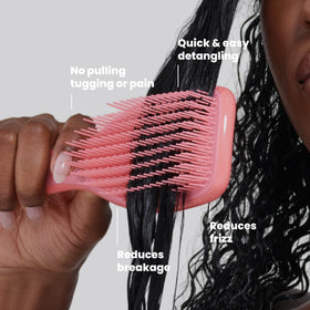 TANGLE TEEZER held in hand to show size and portability for on-the-go curl care
