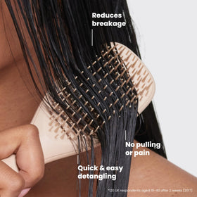 TANGLE TEEZER held in hand to show scale and travel-ready convenience and fit