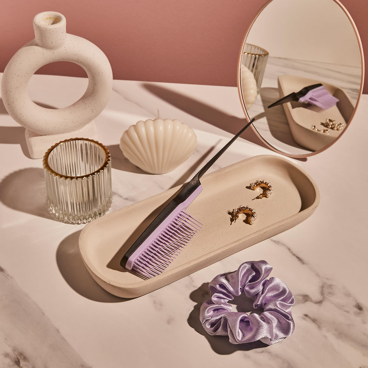 TANGLE TEEZER held in hand to show compact size and travel-friendly convenience