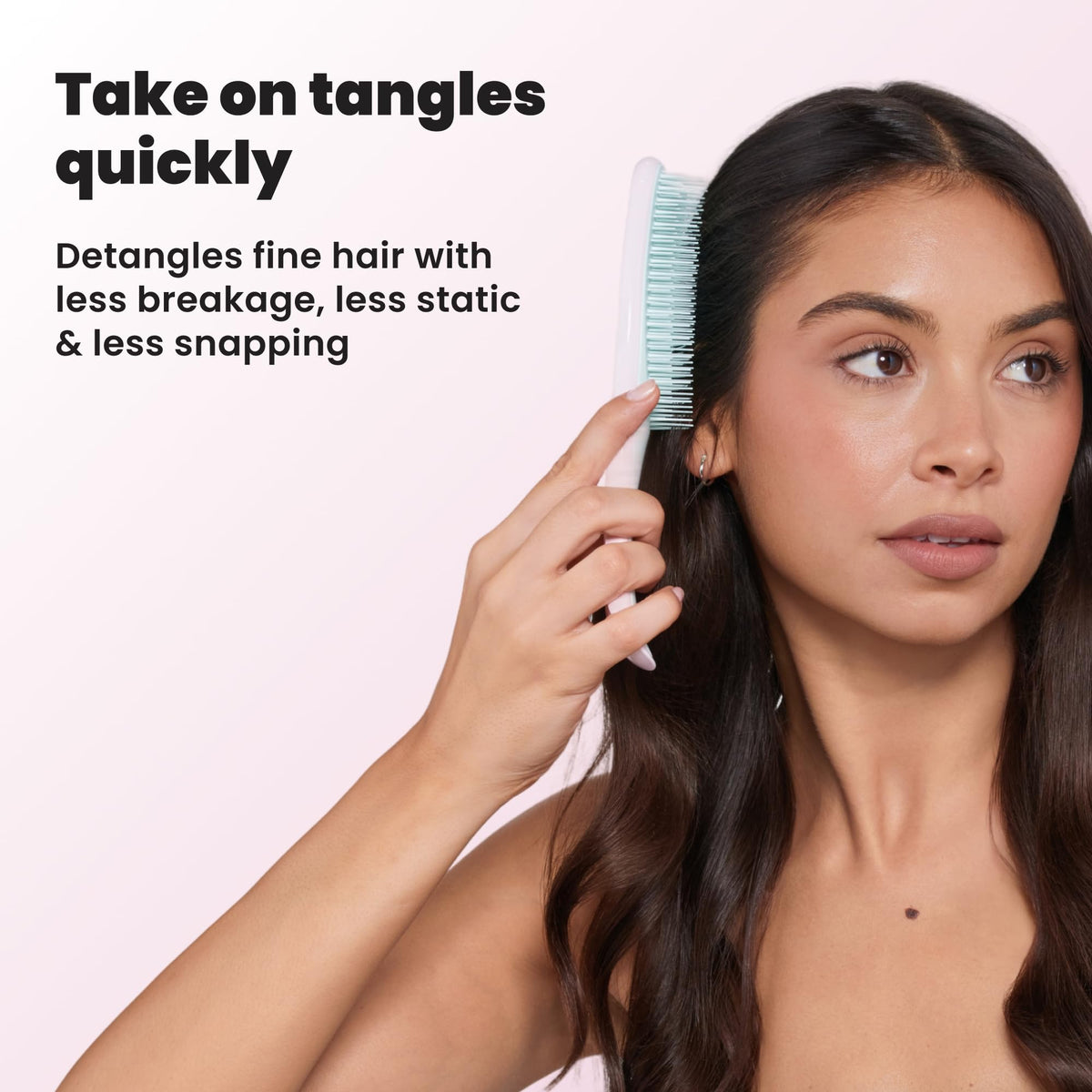 TANGLE TEEZER beside a hand for size comparison, compact travel-friendly design