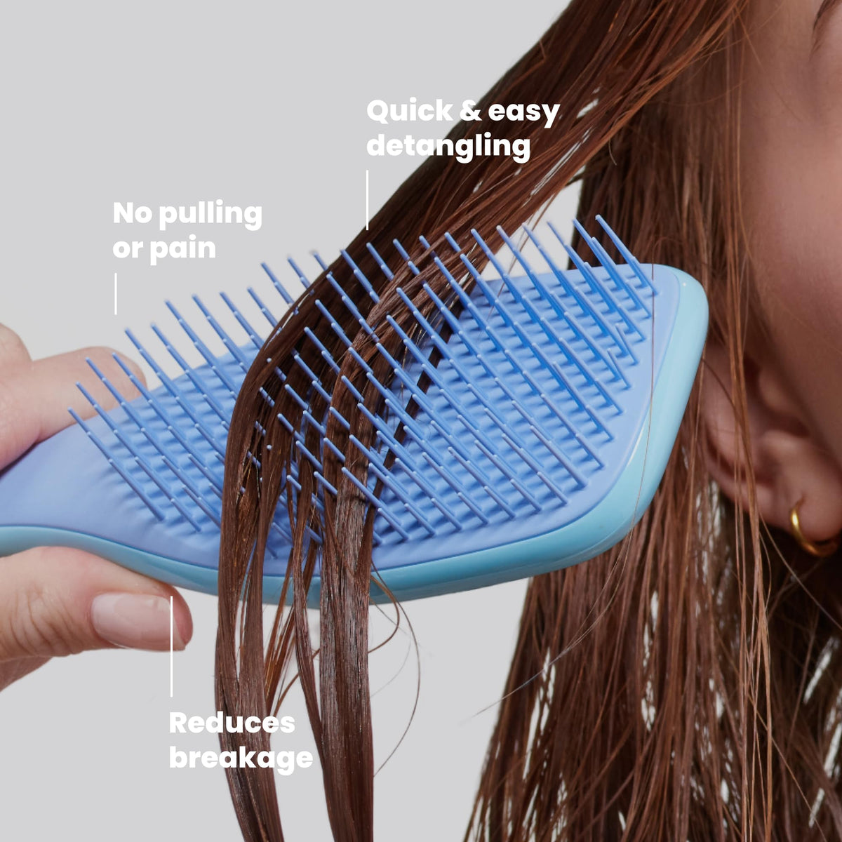 TANGLE TEEZER held in hand to show size and easy one-handed control