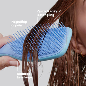 TANGLE TEEZER held in hand to show size and easy one-handed control