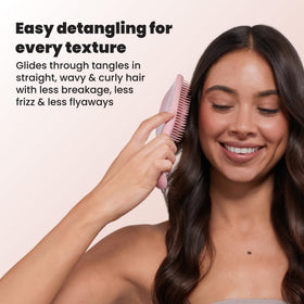 TANGLE TEEZER held in hand to show size and travel-friendly convenience