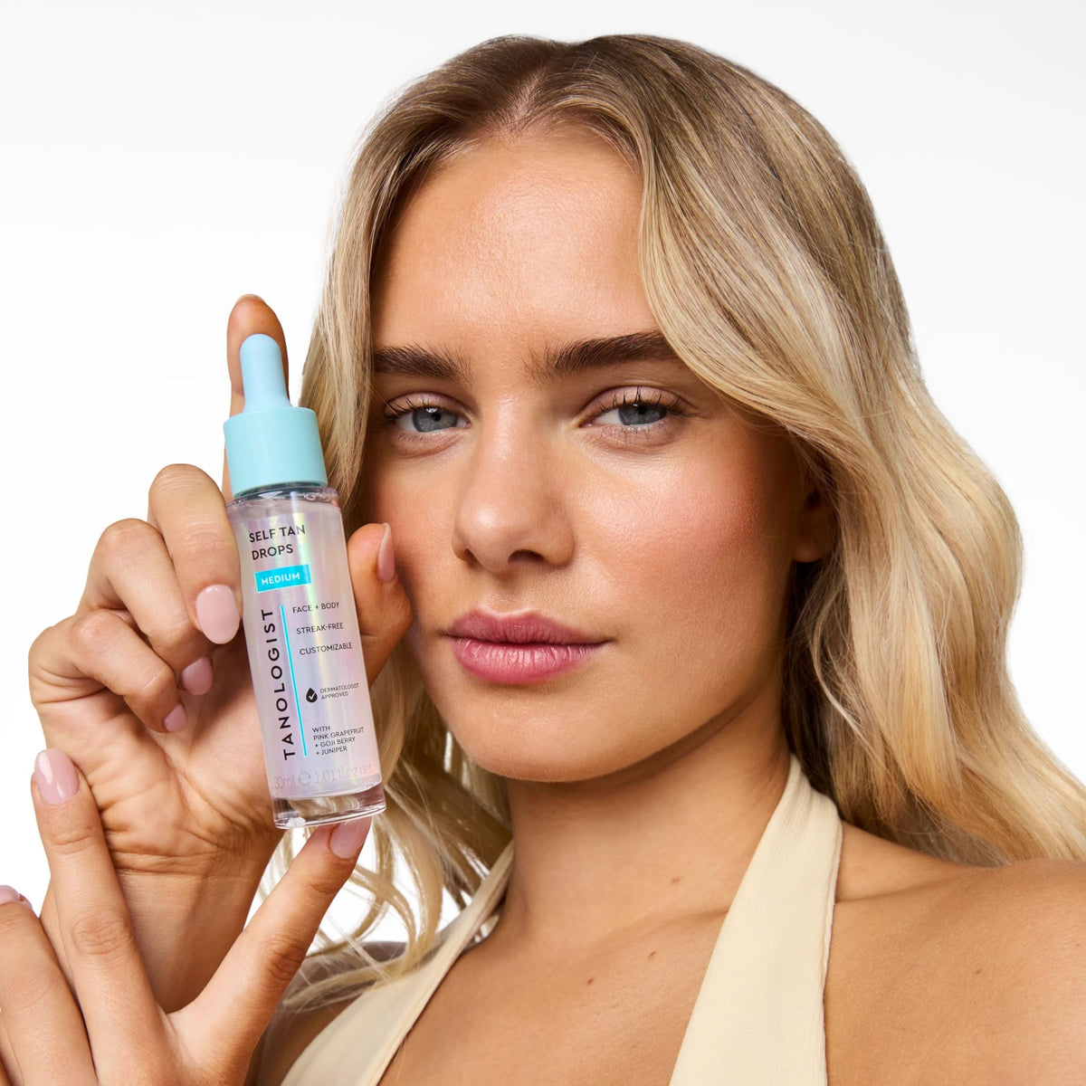 Tanologist size comparison in hand showing compact 1.01 fl oz bottle ideal for travel