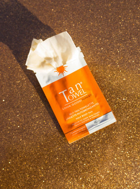 Applying a TanTowel towelette to forearm for streak-free medium-to-dark tan, fast-drying benefit