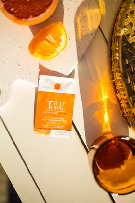 Close-up texture of a TanTowel towelette soaked with clear self-tanning solution for even coverage