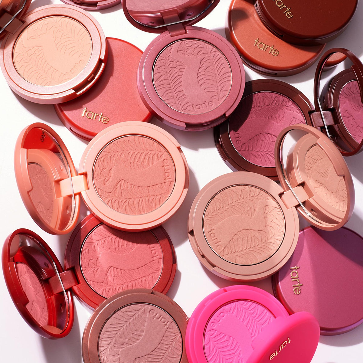 tarte styled flatlay with compact and brush suggesting everyday makeup routine