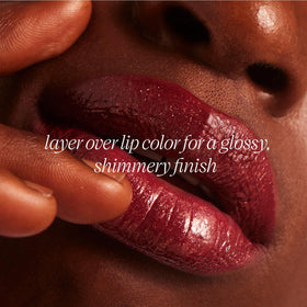 TATCHA The Kissu Gold Leaf next to a hand to show compact size and travel-friendly convenience
