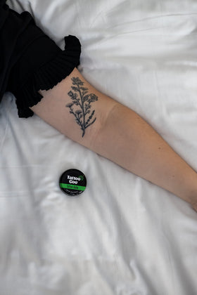 Applying Tattoo Goo balm to healed tattoo area to hydrate and preserve color