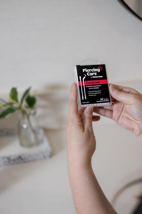 Tattoo Goo swabs in a travel bag illustrating easy on-the-go piercing care