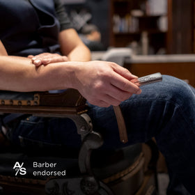 The Art of Shaving tube next to travel items showing compact, carry-on friendly size