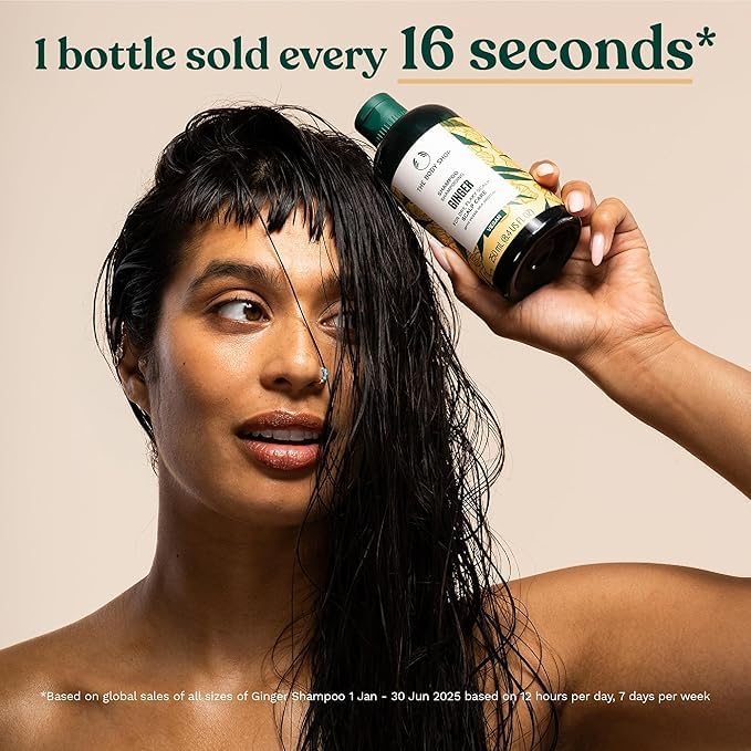 The Body Shop ginger shampoo held in hand to show 13.5 oz scale