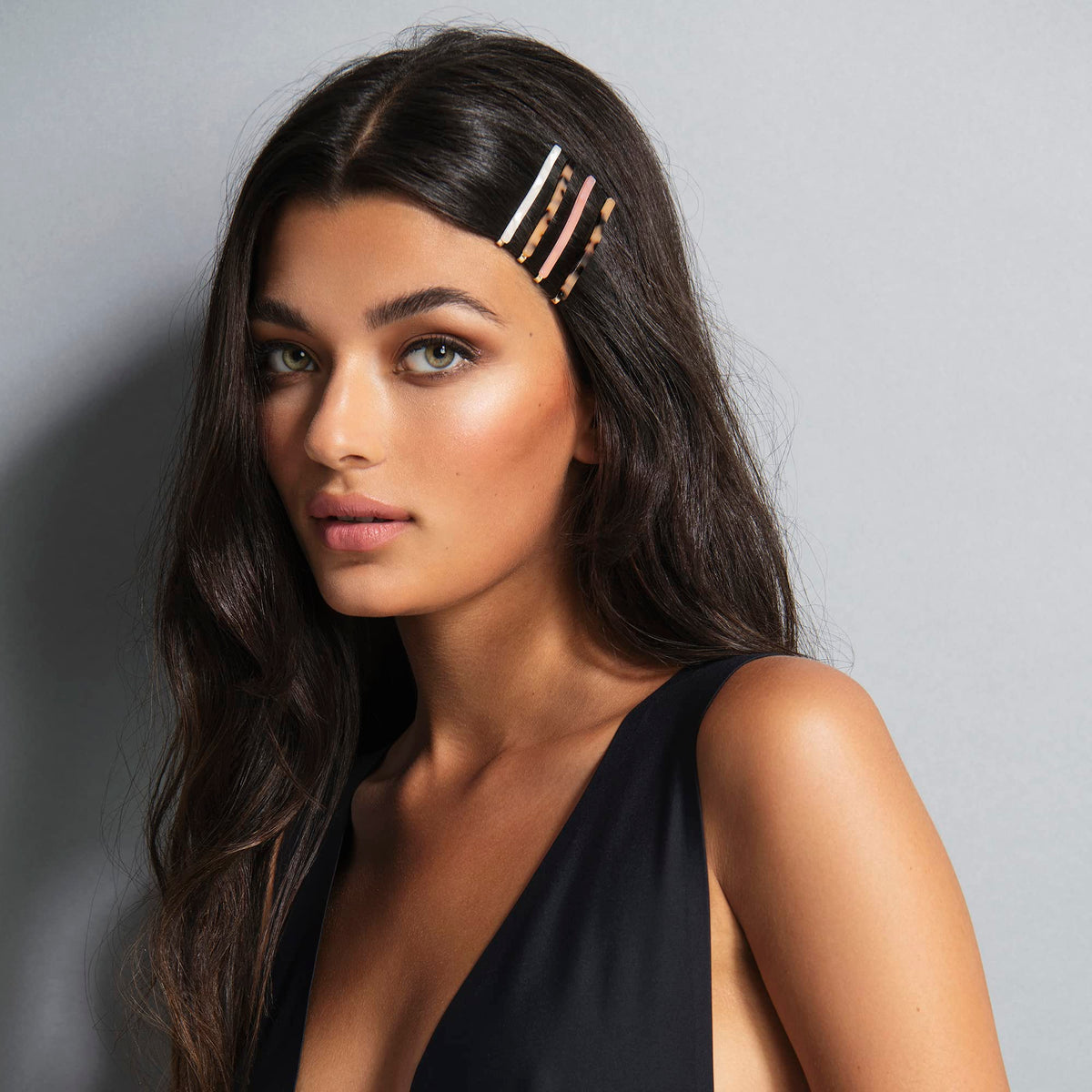 The Hair Edit marble bobby pins in hand for scale showing slim profile and lightweight comfort