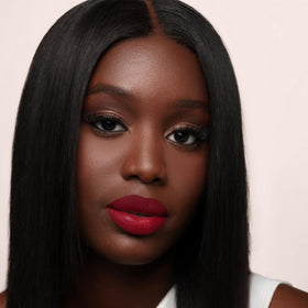 Styled flatlay of The Lip Bar Rich Auntie paired with gloss showing layering versatility benefit