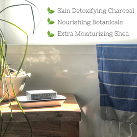 The Yellow Bird rich charcoal lather in hand demonstrating deep-cleaning benefit