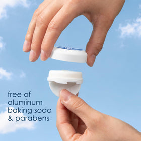 TINI stick next to a hand for scale showing travel-size convenience